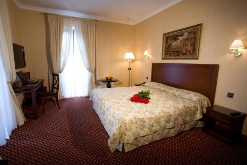 a hotel room with a bed with flowers on it at Optima Collection Kamianets-Podilskyi in Kamianets-Podilskyi
