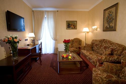 a hotel room with a couch and a table and a living room at Optima Collection Kamianets-Podilskyi in Kamianets-Podilskyi