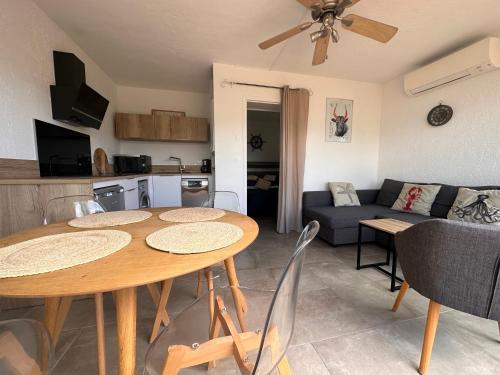 un salon avec une table et un canapé dans l'établissement Appartement La Petite Maison, au Grau-du-Roi