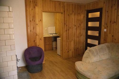 a living room with a couch and a desk with a computer at Domek letniskowy nr 2 Przewięź in Płaska