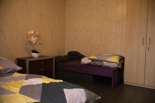 1 dormitorio con 2 camas y una mesa con flores en Domek letniskowy nr 2 Przewięź en Płaska