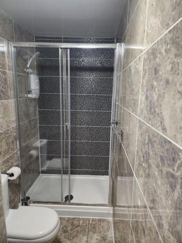a bathroom with a glass shower with a toilet at City Centre 2 Bed 2 Bath 5 guest with Cheapest overnight Car park in Leicester