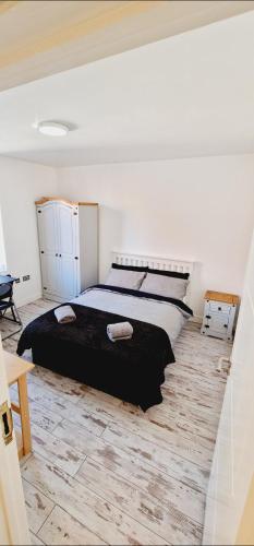 sypialnia z dużym łóżkiem i drewnianą podłogą w obiekcie City Centre 2 Bed 2 Bath 5 guest with Cheapest overnight Car park w mieście Leicester