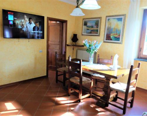 ein Esszimmer mit einem Tisch, Stühlen und einem TV in der Unterkunft La Cheta in Monsagrati