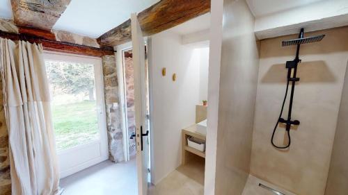 uma casa de banho com um chuveiro, um lavatório e uma janela em Une pause en Corrèze em Sarroux