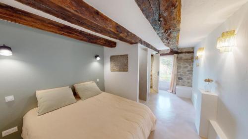 um quarto com uma cama num quarto com tectos em madeira em Une pause en Corrèze em Sarroux