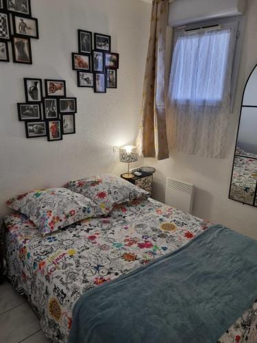 une chambre avec un lit et des tableaux au mur dans l'établissement Naturiste Cap d'Agde Natura Beach 107, au Cap d'Agde