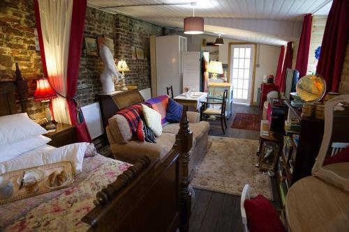 a living room with a bed and a couch at a quirky garden building in an orchard in Ryton