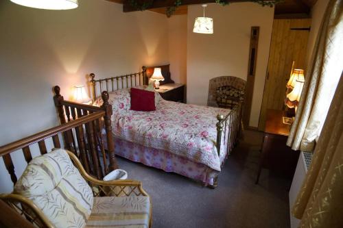 1 dormitorio con 1 cama y 1 silla en una habitación en Cosy secret cottage in a beautiful walled garden, en Ryton