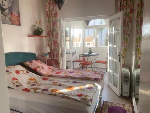 a bedroom with a bed and a window and a table at Appartment Avenue Hassan II in Agadir
