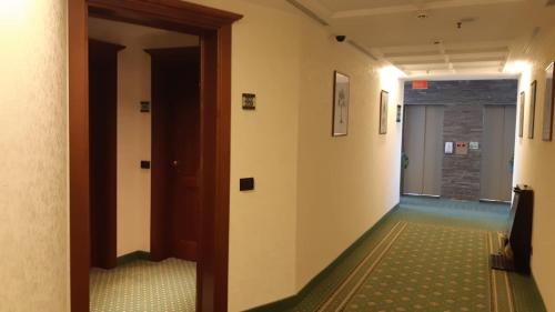 a hallway of an office with a door and a room at Lux Garden Hotel in Azuga