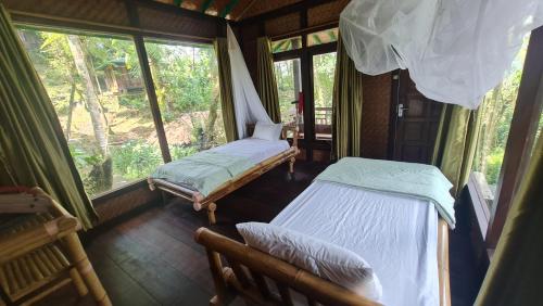 two beds in a room with a window at Rimba eco Resort in Tomohon