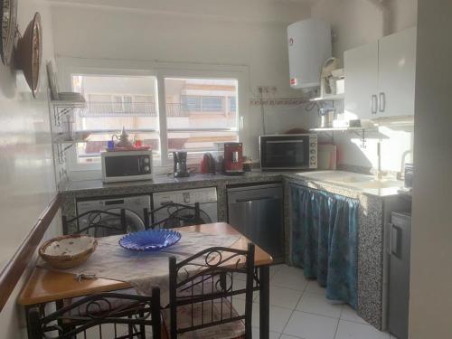 a kitchen with a table and chairs in it at Appartment Avenue Hassan II in Agadir