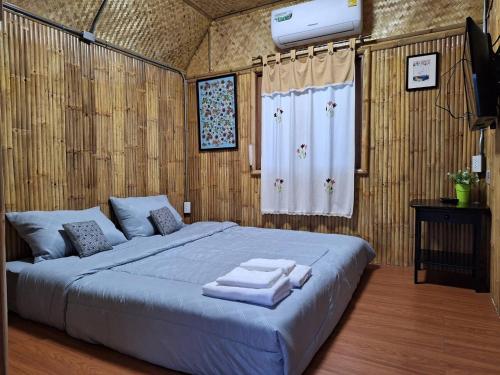 a bedroom with a large bed with towels on it at คูณ-เนื่อง ฟาร์ม สเตย์ หัวหิน Koon & Nueang Farm Stay Hua Hin in Ban Bo Fai (1)