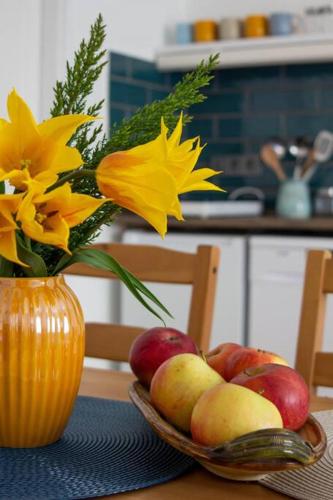a bowl of fruit and a vase with flowers on a table at Diófa Vendégház, Zebegény in Zebegény