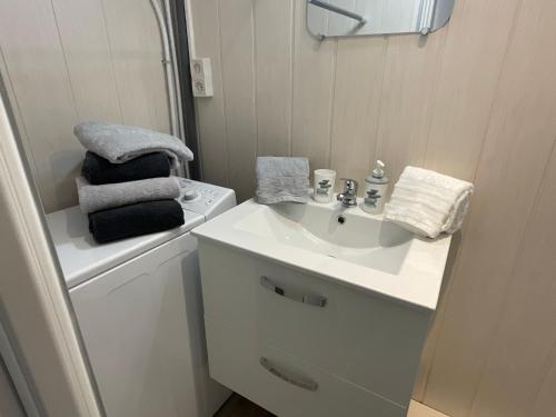een badkamer met een witte wastafel en een spiegel bij ENTRE MER ET ARENE in Le Grau-du-Roi