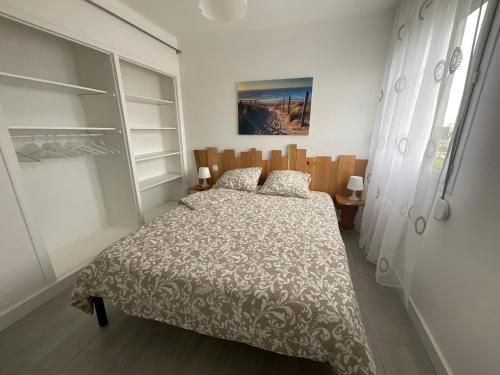 1 dormitorio con cama y ventana en ENTRE MER ET ARENE, en Le Grau-du-Roi