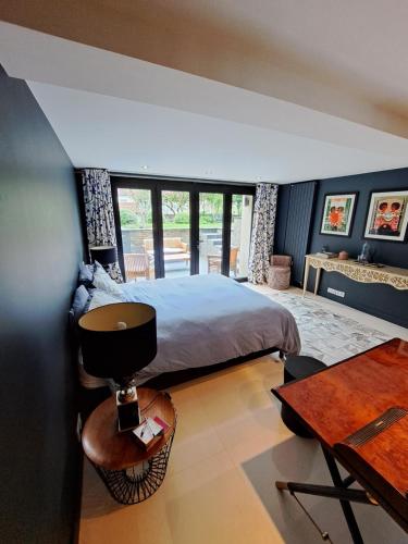 a bedroom with a bed and a desk and a table at Havre de paix in Ville-dʼAvray