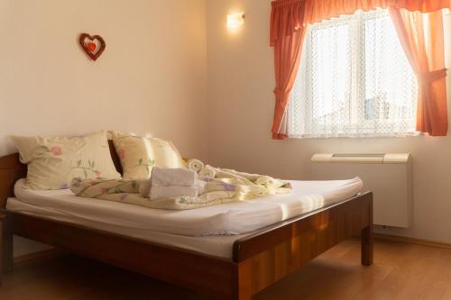 Schlafzimmer mit einem Bett mit weißer Bettwäsche und einem Fenster in der Unterkunft Villa Chiara in Krnica