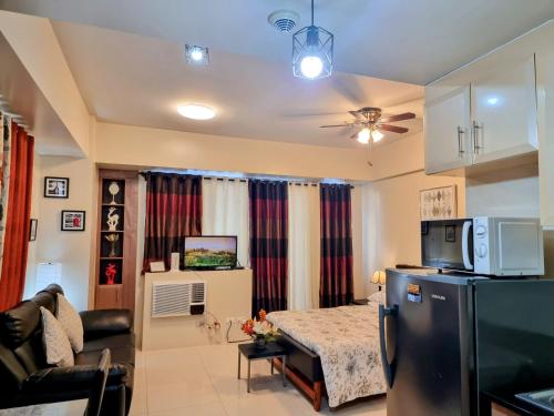 uma sala de estar com um sofá e uma televisão num quarto em Condo Airport NAIA Terminal-3 One Palm Tree Villas em Manila