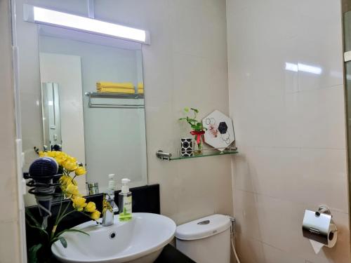 a white bathroom with a sink and a toilet at Condo Airport NAIA Terminal-3 One Palm Tree Villas in Manila