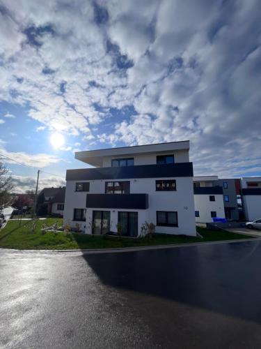 a white building with a cloudy sky in the background at Traube in Balingen