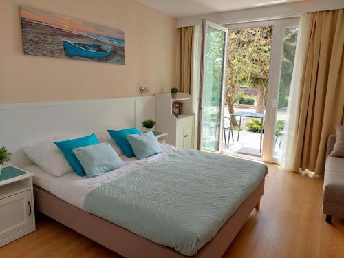 a bedroom with a large bed with blue pillows at Szárszó Holiday Apartman in Balatonszárszó