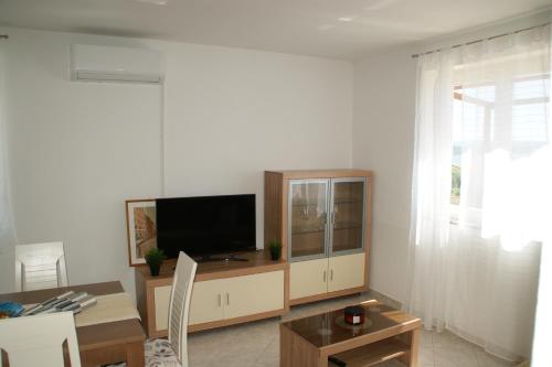 sala de estar con TV y mesa en Apartments Brko, en Maslenica