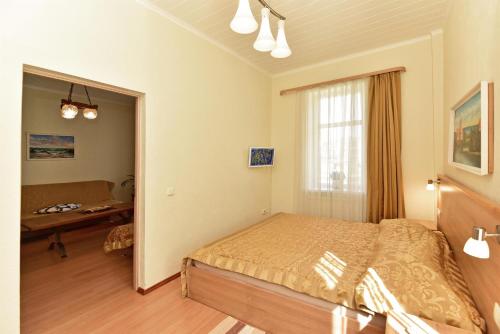 a bedroom with a bed and a table and a window at Dalija in Druskininkai