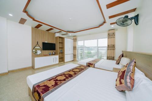 a hotel room with two beds and a television at My Ngoc Hotel in Cat Ba