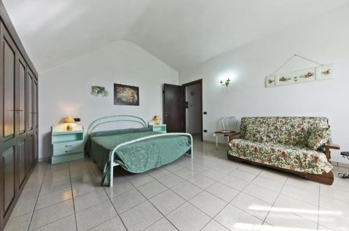 ein Schlafzimmer mit einem grünen Bett und einem Sofa in der Unterkunft Appartamenti Poggio Rineschi in Montenero