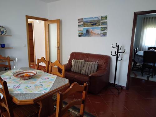 una sala de estar con una mesa y un sofá en Casa do Campo, en Seia
