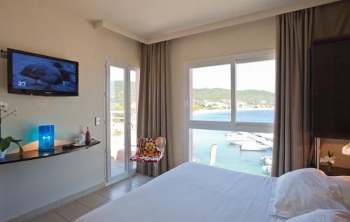 a bedroom with a bed and a view of the ocean at Le Golfe in Porto Pollo