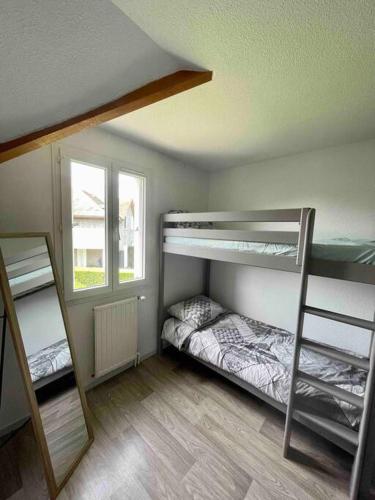 une chambre avec deux lits superposés et une fenêtre dans l'établissement Petite Maison dans les Pyrénées, à Argelès-Gazost