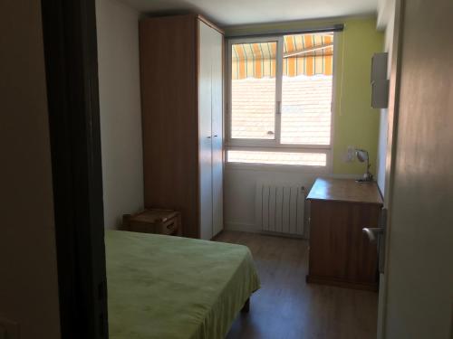 une petite chambre avec un lit et une fenêtre dans l'établissement Appartement entier 3 pièces face au port, à Vallauris