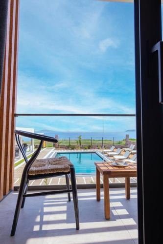 a balcony with a table and a view of a pool at Leone Cunda Edition Otel in Ayvalık