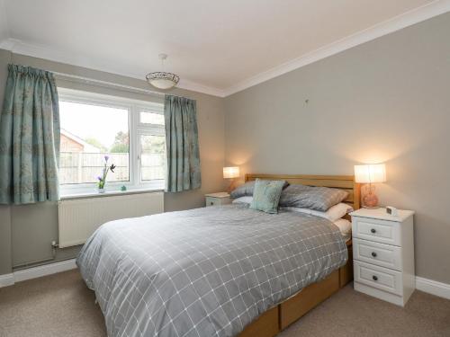 1 dormitorio con cama y ventana en 32 Queen Elizabeth Drive, en Dersingham