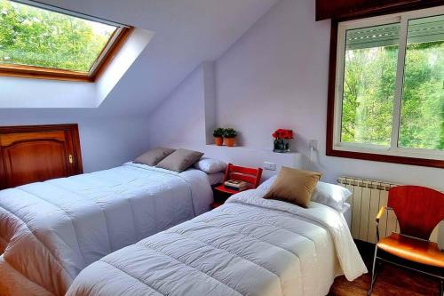 1 dormitorio con 2 camas y ventana en Casa MATRIA en Ponteareas
