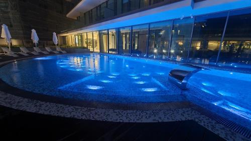 a large swimming pool in a building at night at Wave by Baltic Home in Międzyzdroje