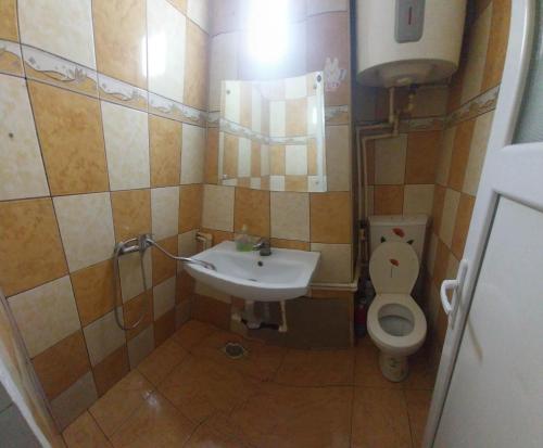 Un baño pequeño con lavabo e inodoro. en Garsoniera, en Buzau