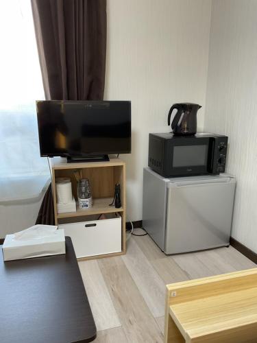 a living room with a television and a microwave at ザ・ミッキーカールトン井尻201 in Shiobaru