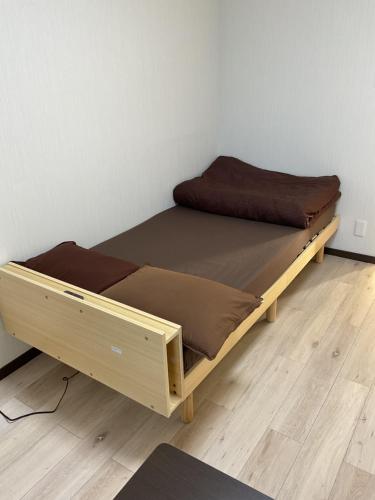 a bed with a wooden frame in a room at ザ・ミッキーカールトン井尻201 in Shiobaru