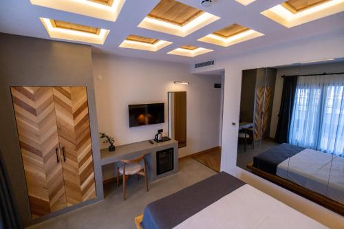 a bedroom with a bed and a desk and a tv at Leone Cunda Edition Otel in Ayvalık