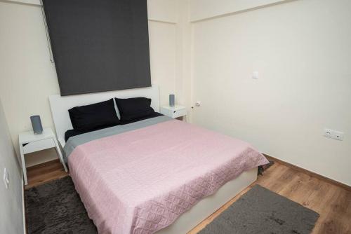 - une chambre avec un grand lit et une couverture rose dans l'établissement Seacoast Apartments 1 !, à Kamena Vourla