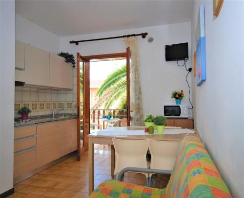 リニャーノ・サッビアドーロにあるAppartamenti Villaggio Giardinoのキッチン、ダイニングルーム(テーブル、椅子付)