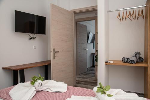 Cette chambre dispose d'un lit, d'une télévision et d'une porte. dans l'établissement Nausika Rustic Cottage, à Paleokastritsa