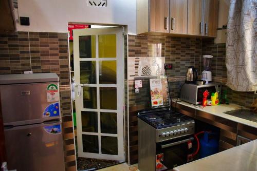 a kitchen with a refrigerator and a stove at Greenstar suites in Bungoma