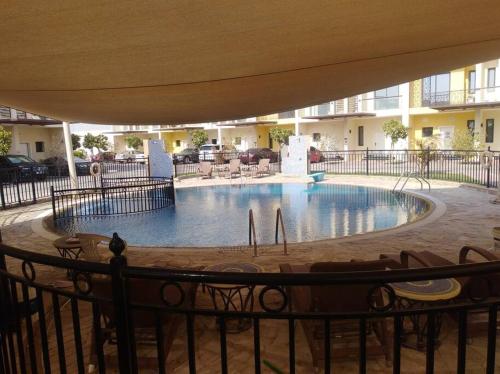 a large swimming pool in a building with an umbrella at Luxurious 3bhk Villa in Dubai in Dubai