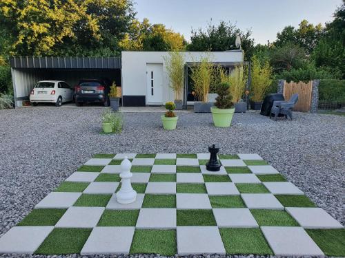 un tablero de ajedrez en un patio con una casa en Jungle, en Mios