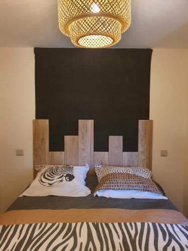 a bedroom with a bed with a black headboard at Jungle in Mios